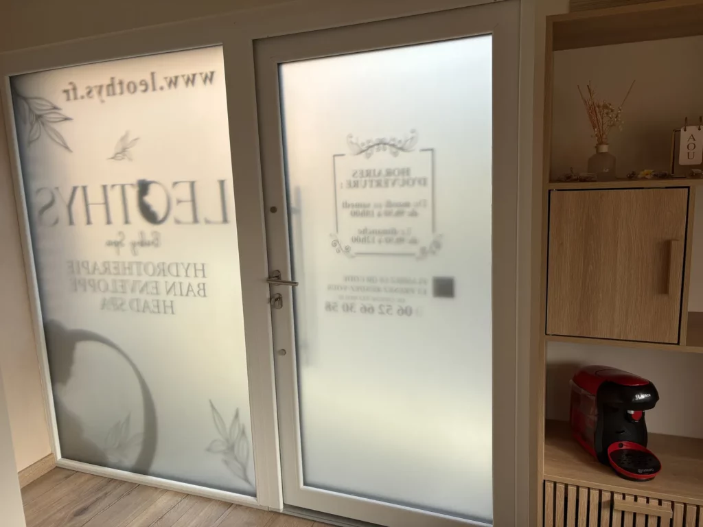 Film dépoli imprimé sur porte vitrée d'un institut vu de l'intérieur à Maing